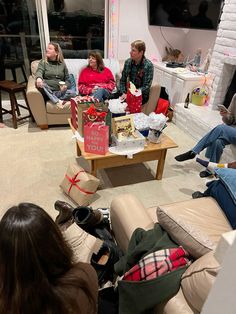 group of people sitting on couches in living room with presents wrapped around the table