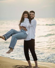 a man holding a woman on the beach