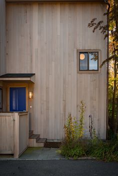 a house that is made out of wood and has a blue window on the side