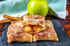 apple turnovers stacked on top of each other next to cinnamon sticks and an apple