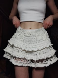 a woman is wearing a white skirt with ruffles