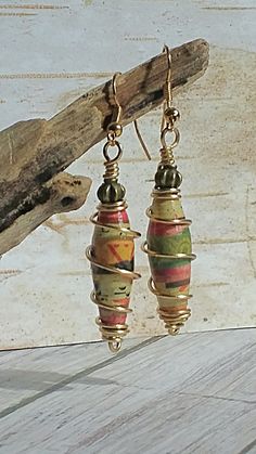 the earrings have been made with colorful beads and gold plated wire, on top of wood