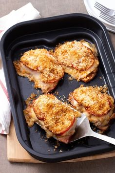 four pieces of chicken in a pan with a spatula on the side, ready to be cooked