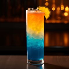 a blue, yellow and orange drink sitting on top of a table