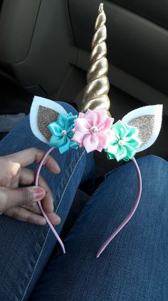 a person sitting in the back seat of a car wearing a unicorn horn headband