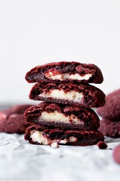 three red velvet cookies stacked on top of each other with cream filling in between them