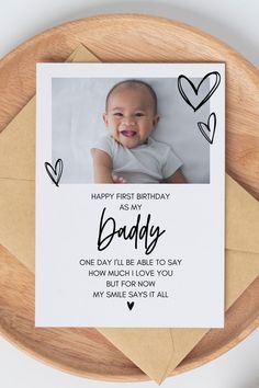 a birthday card for a baby is shown on a wooden plate with hearts around it