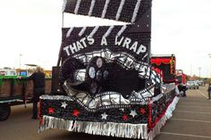 a parade float is decorated with black, white and red decorations on it's side