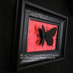 a black and red butterfly in a frame