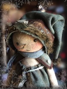 a stuffed animal with a hat and scarf on it's head is wearing feathers