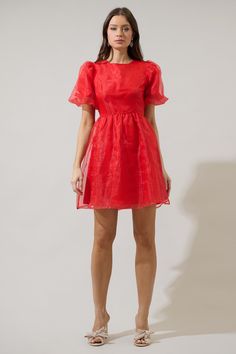 If you like to be trendy, you need Borza Organza Mini Dress! It’s such an adorable dress that has angled, ruffled short sleeves. The back side has an invisible zipper closure followed by a big bow tie back detail. Bodice has a relaxed fit and has a flowy skirt with an organza fabric all over this dress. It will look cuter with heels and your favorite jewelry pieces. - Lined- Puffed short sleeves- Bow details- Zipper back- Comes in 2 colorsSize + Fit - Model is 5'10" and wearing size XS- Measurem A-line Puff Sleeve Dress With Ruffles For Party, Summer Evening A-line Short Sleeve Dress, Puff Sleeve Dress With Ruffle Hem For Party, Summer Puff Sleeve Dress With Ruffles For Night Out, Short Sleeve Dress With Back Zipper For Night Out, Flirty Puff Sleeve Dress For Party, Night Out Dresses With Short Sleeves And Back Zipper, Flirty Flutter Sleeve Mini Dress For Party, Puff Sleeve A-line Dress With Ruffles For Parties