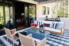 an outdoor living area with furniture and flowers on the table