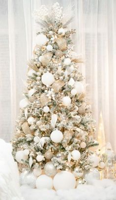 a white christmas tree with silver and gold ornaments