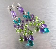 "Mixed Metal Amethyst, Peridot and Quartz Dangle Earrings. Large faceted amethyst rondelles have been wrapped in hand coiled stations, and form the base of wire wrapped tendrils consisting of AAAquality peridot, amethyst and teal blue quartz.. I have alternated the wire to wrap the tendrils, in oxidized silver and shiny sterling silver wire. The entire cluster hangs from sterling silver Bali made ear wires. The earrings measure 3 3/8\"(85mm.) from the top of the ear wires" Amethyst Multi-stone Briolette Earrings, Green Faceted Amethyst Jewelry, Girls Accesories, Earrings Large, Wire Crafts, Blue Quartz, 925 Silver Jewelry, Oxidized Silver, Etsy Earrings Dangle