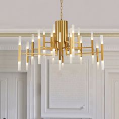 a chandelier hanging from the ceiling in a room with white walls and cabinets