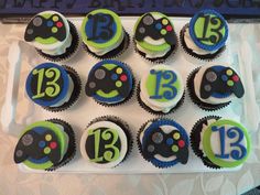 cupcakes decorated with numbers and video game controllers on a tray in front of a happy birthday sign