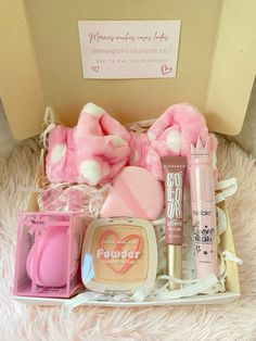 a pink teddy bear sitting on top of a bed next to cosmetics