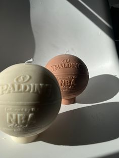 two soap balls sitting next to each other on a white counter top with the words paddin and nea printed on them