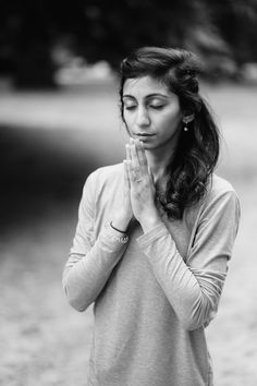 a woman with her hands together praying