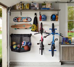 there is a bike hanging on the wall next to some sports related items and other things