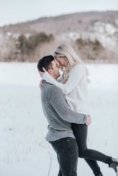 a man and woman are kissing in the snow