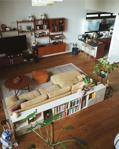 a living room filled with furniture and a flat screen tv mounted on a wall next to a wooden floor