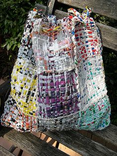 a bag made out of plastic bags sitting on top of a wooden bench