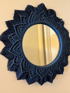 a round blue mirror hanging on the wall