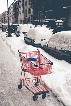 a shopping cart is covered in snow on a city street