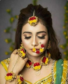 a woman with flowers on her face and jewelry around her neck, wearing a yellow outfit