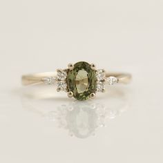 an oval shaped green and white diamond ring