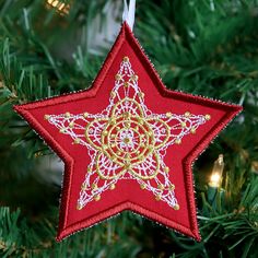 a red star ornament hanging from a christmas tree