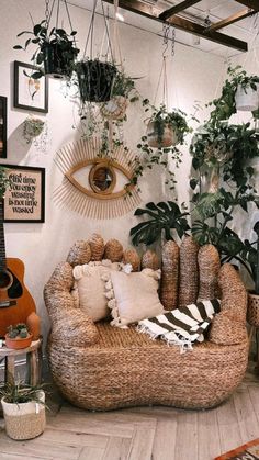 a living room filled with lots of potted plants next to a wall mounted guitar