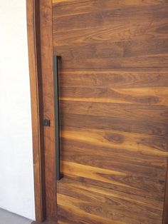 a close up of a wooden door with a metal handle on the front and side