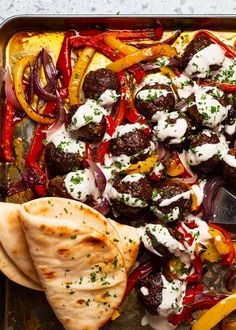 a tray filled with meat and vegetables covered in sauces, sour cream and seasonings