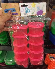 plastic cups are stacked on top of each other in a display case at a store