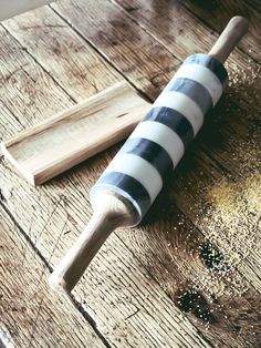 a wooden rolling pin sitting on top of a wooden table next to a knife and some spices