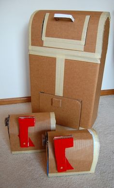 two cardboard boxes with red tape on them sitting on the floor next to each other