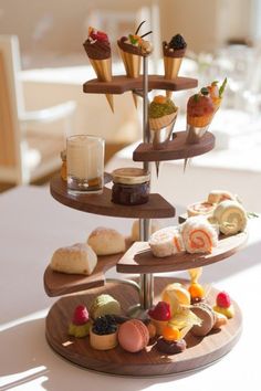 three tiered trays filled with different types of pastries on top of a table