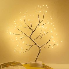 a lighted tree sitting on top of a book