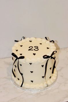 a white cake with black hearts on it and the number twenty two in the middle