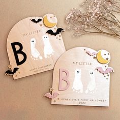 two personalized wooden halloween tags with bats and moon on the front one is for a child's first halloween