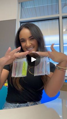 a woman is holding up some cards in front of her face and smiling at the camera