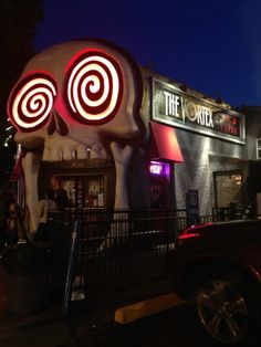 a building with a giant skull in front of it that has spirals on its face