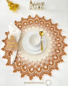 a crocheted doily with a cup and saucer on it