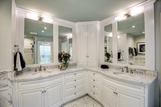 a large bathroom with double sinks and mirrors on the wall, along with marble tile flooring