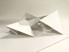 an origami sculpture sitting on top of a white surface