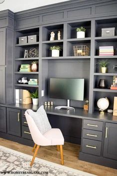 an office with built - in shelving, desk and chair