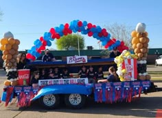 people are riding in the back of a truck decorated with balloons and streamers