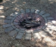 a fire pit made out of bricks and logs